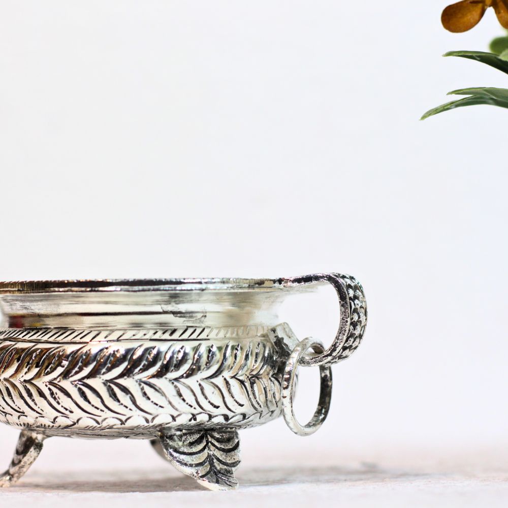 Small brass urli with silver-tone finish — ring handle and leaf details