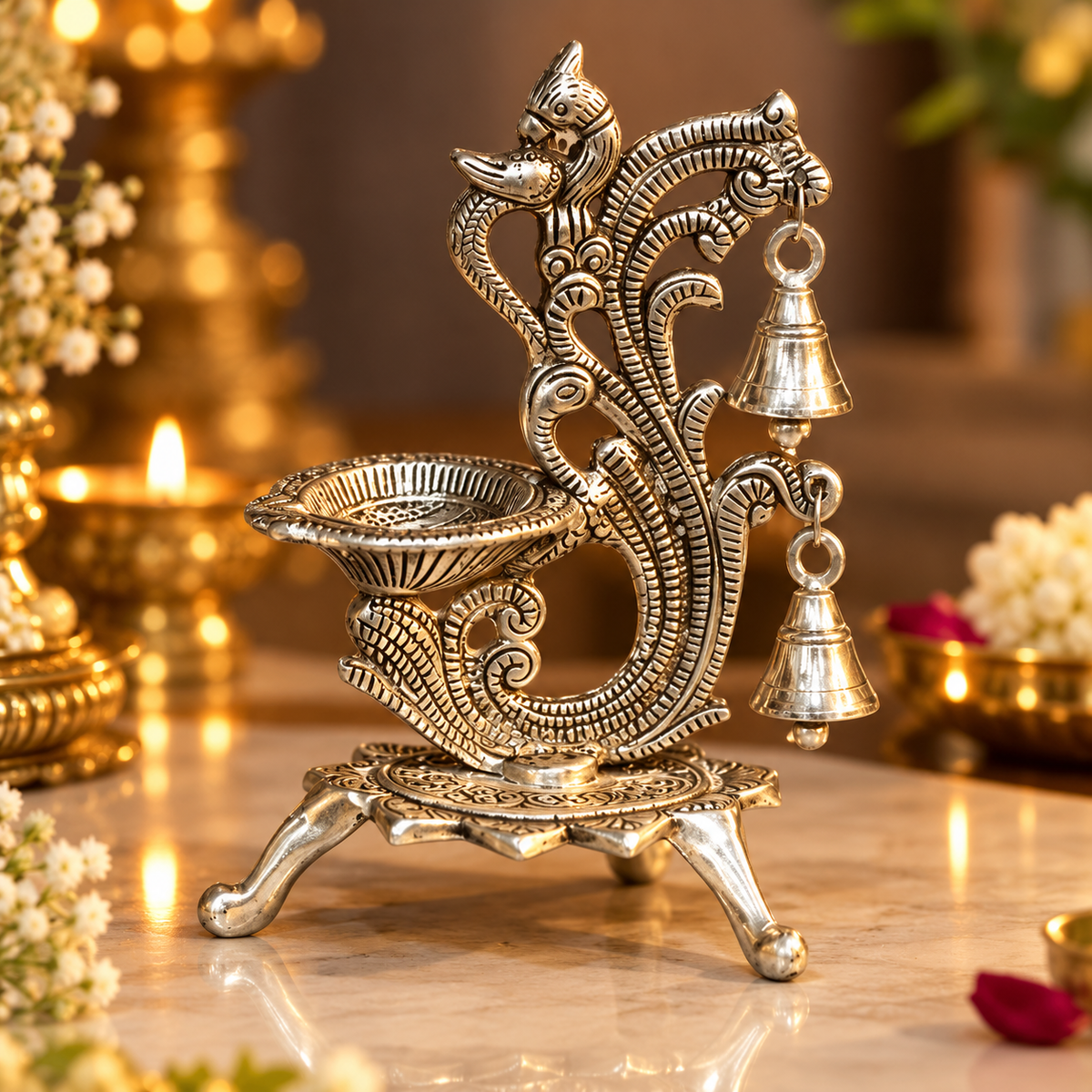 Mayur Naad Heritage Jyot with a silver-toned peacock design, diya bowl and two hanging bells.