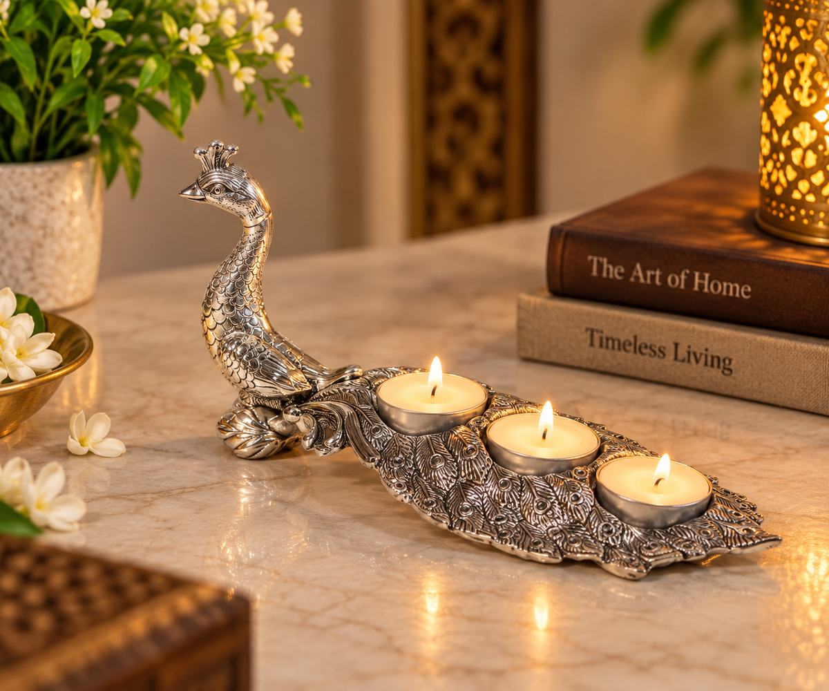 Metal peacock tealight holder with three lit candles