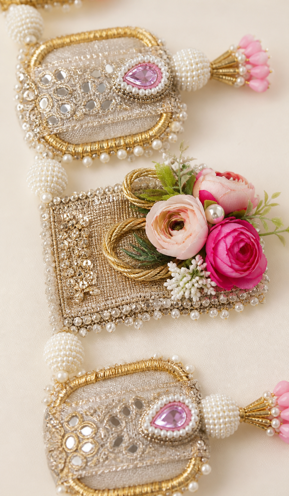 Handmade floral toran with pink flowers, gold-tone panels and pearl-like beads
