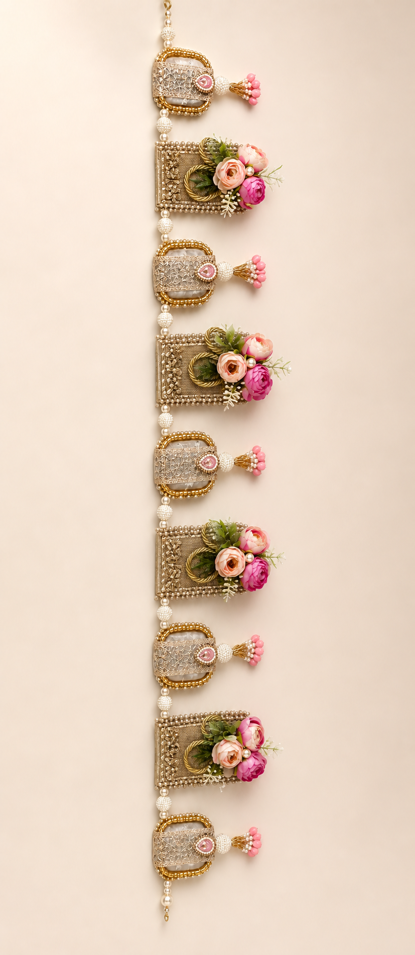 Handmade floral toran with pink flowers, gold-tone panels and pearl-like beads