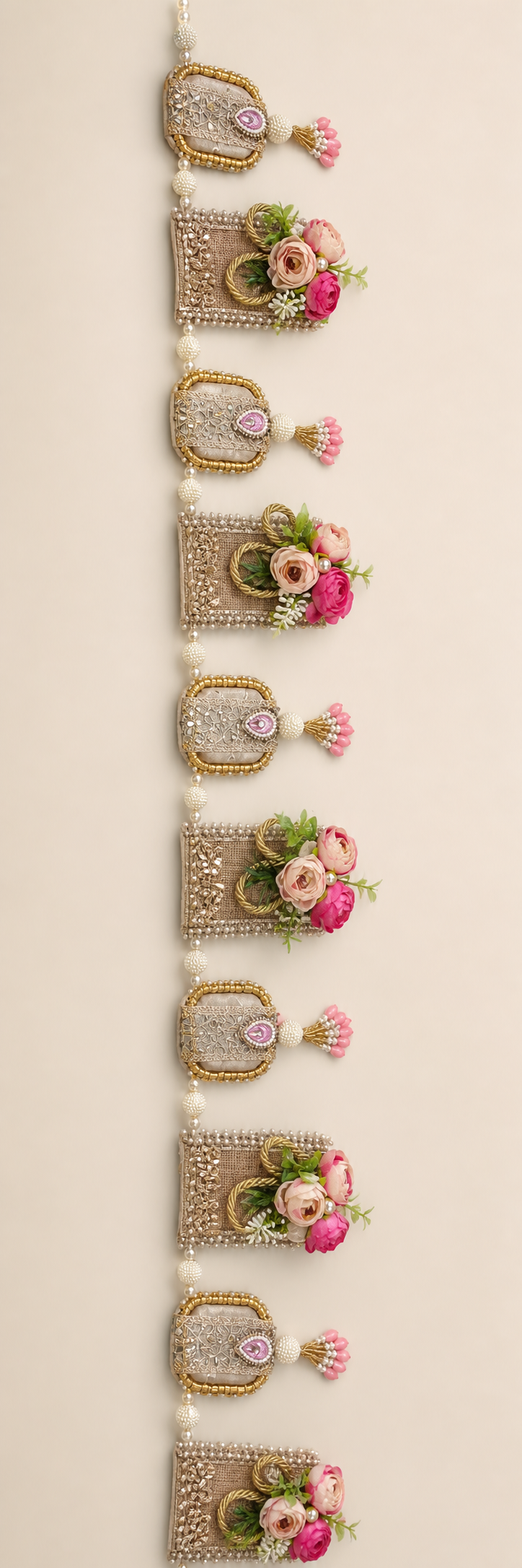 Handmade floral toran with pink flowers, gold-tone panels and pearl-like beads