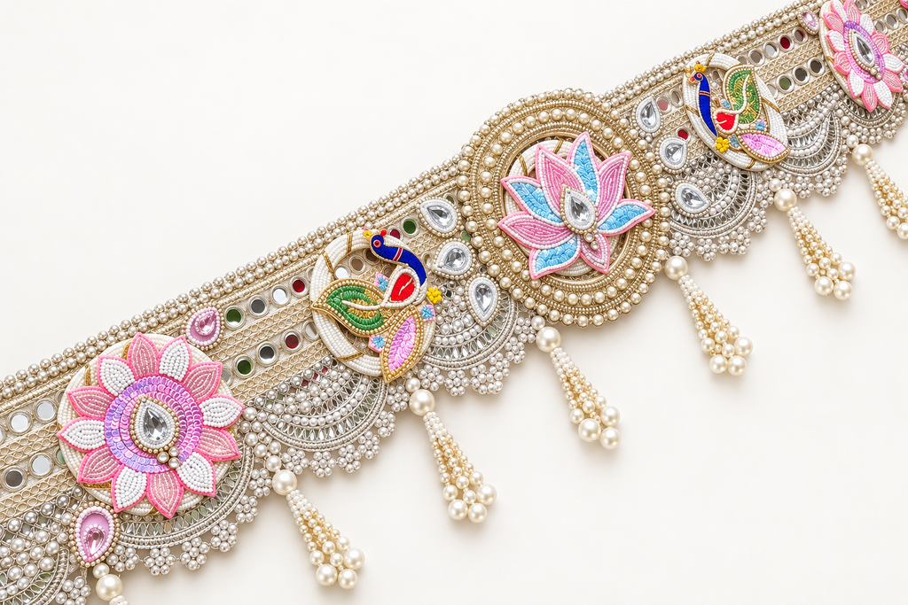 Close-up of lotus, peacock, reflective accents and pearl-like bead tassels on handmade toran