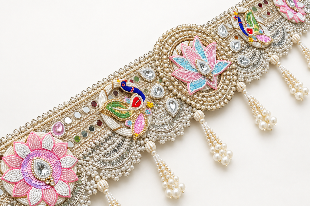 Close-up of lotus, peacock, reflective accents and pearl-like bead tassels on handmade toran